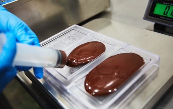 injecting chocolate into molds with a syringe