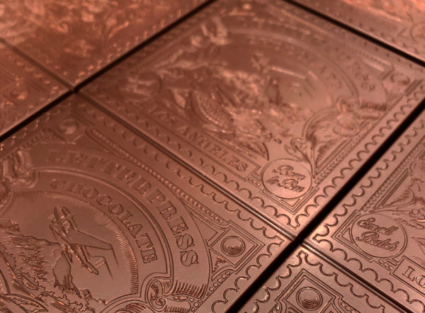 close up view of tempered chocolate bars with letterpress chocolate logo
