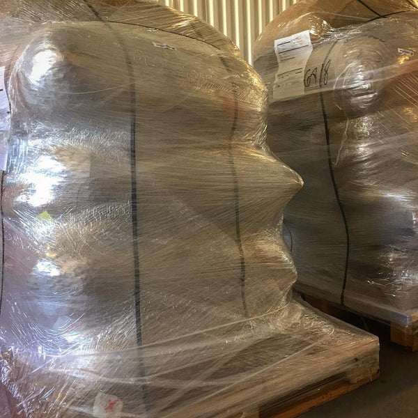 two pallets of cacao bean bags stacked and wrapped in clear plastic