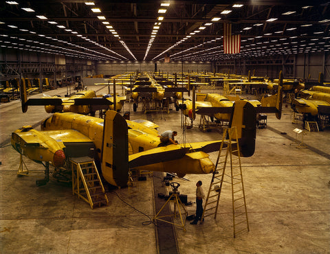 A vintage photograph of men assembling B-25 bombers in a large warehouse