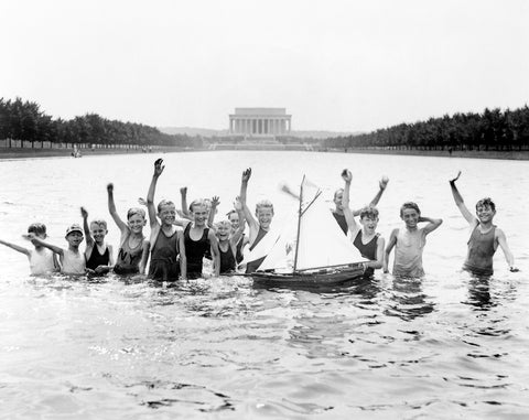 A vintage photograph of a group of children playing in the reflecting pool in Washington DC