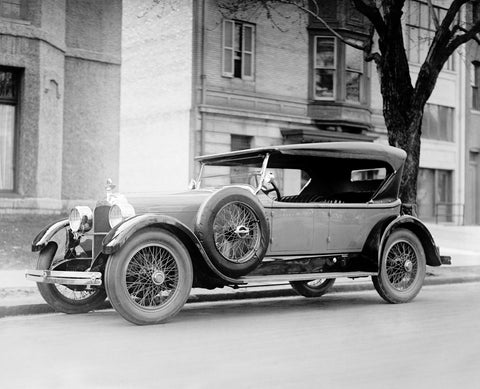 A vintage photograph of a Dusenberg car parked on the street