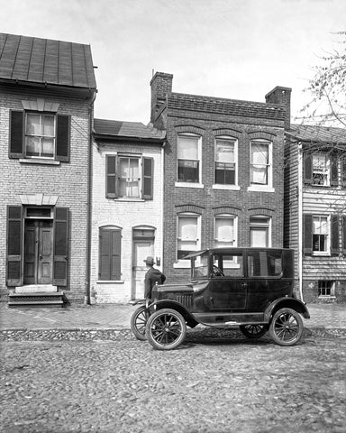 A vintage ford coupe parked in front of the spite house in Alexandria