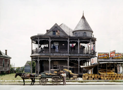 A vintage photograph of a home in Houston with a food stand by the street