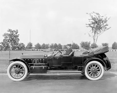 A vintage photograph of a man sitting in a Marmon Motor Car Company vehicle