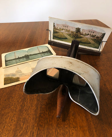 A photograph showing a stereograph viewer with several stereograph cards
