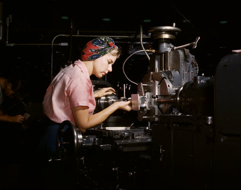 A color photograph of a woman working on airplane parts in 1942