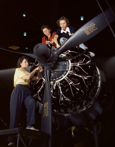 A vintage color photograph of three women working on a C-47
