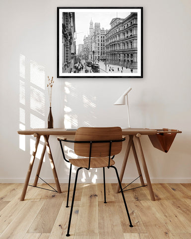 A framed print of a vintage photograph hanging above a desk