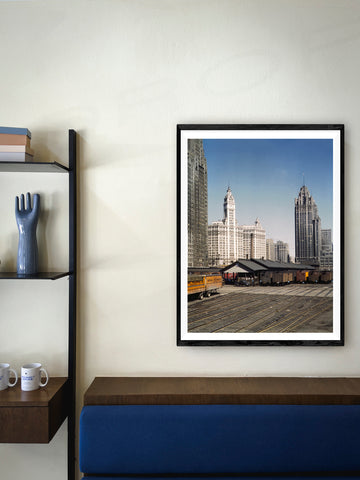 A framed paper print hanging in a room decorated with blue accents