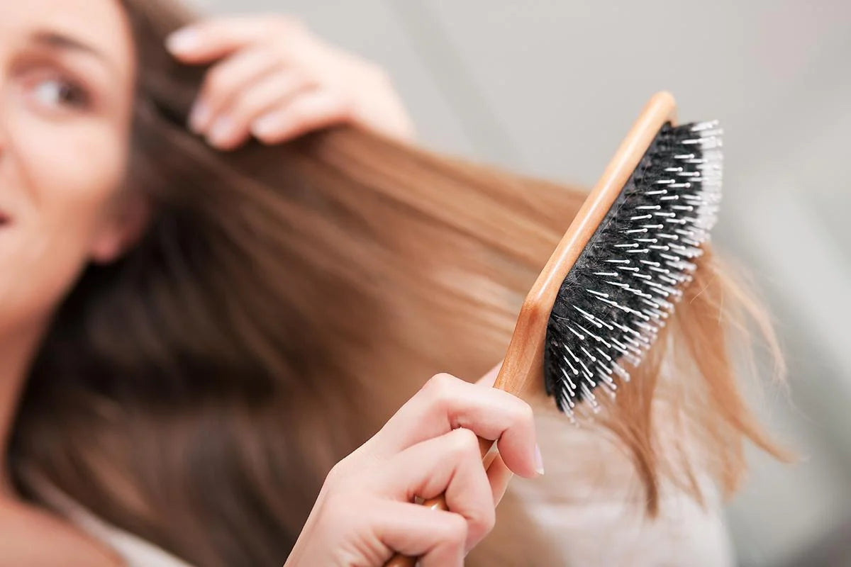 A graceful girl elegantly brushing her hair, capturing a moment of self-care and beauty routine in this visually appealing alt text.