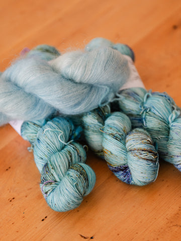 Skeins of blue/green yarn lay in a pile