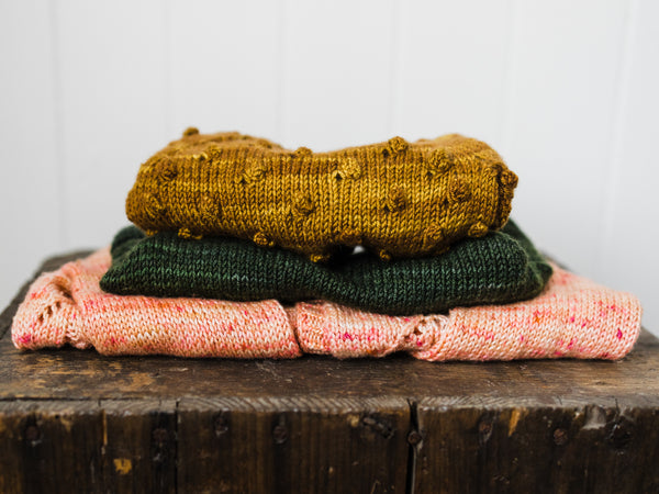 pile of hand knit children's sweaters by Samantha Gehrmann of This Darling Home 