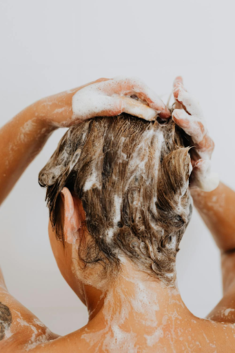 Picture of hair being washed with shampoo.