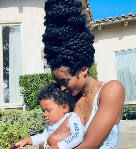 Image of Ciara with her son in the sunshine outdoors, with sectioned twists in an updo.