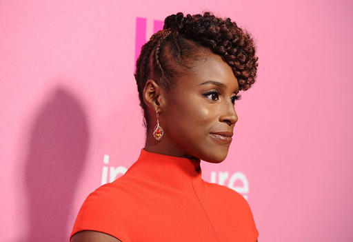 A lady with a flat twist style on her head, with it in a side bun.
