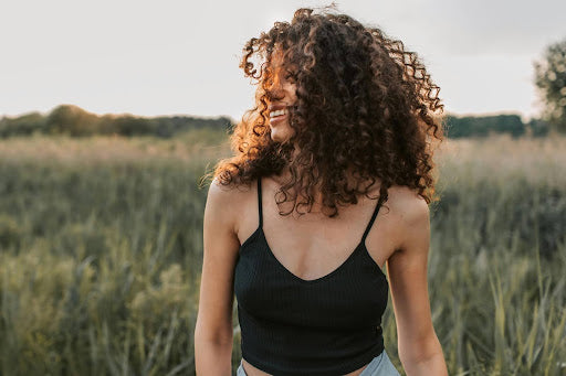Woman outside with mid-length curly hair extensions. Credit: Vlada Karpovich, Pexels.