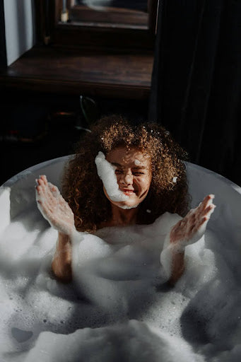 Woman washing her curly hair extensions. Credit: cottonbro studio, Pexels.