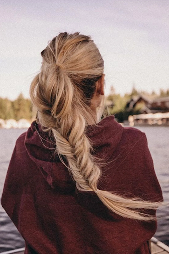 Image of fishtail braid style on a woman with long blond hair and layers
