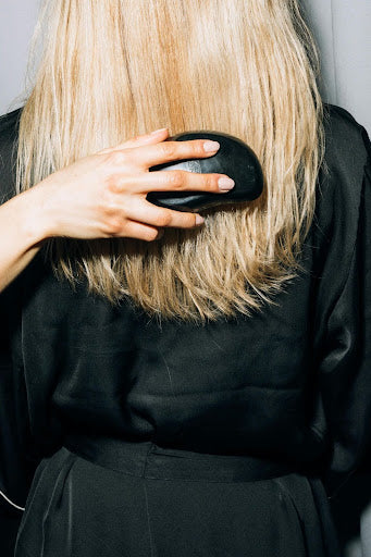 Woman having her hair extensions brushed.