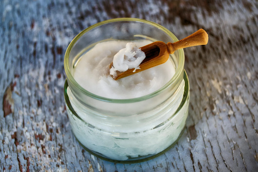 picture of a jar of raw coconut oil being scooped out