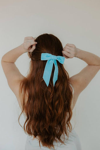 A woman with a velvet bow in her hair, a big hair trend for spring 2024.