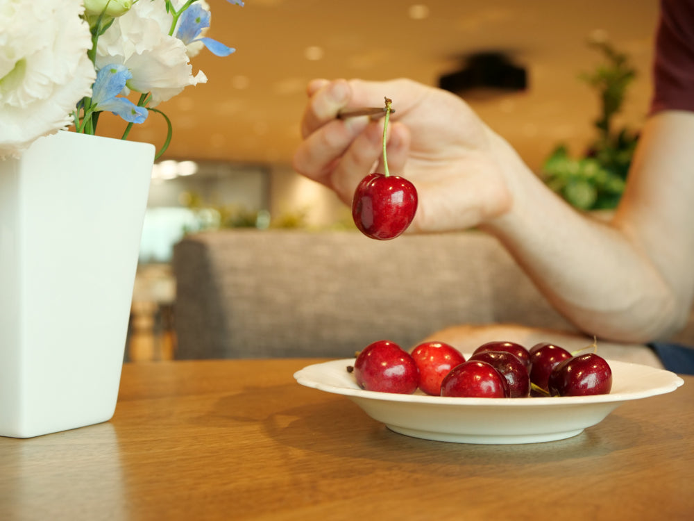 lifting a cherry by the stem with chopsticks