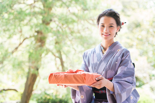 woman giving present wrapped in furoshiki