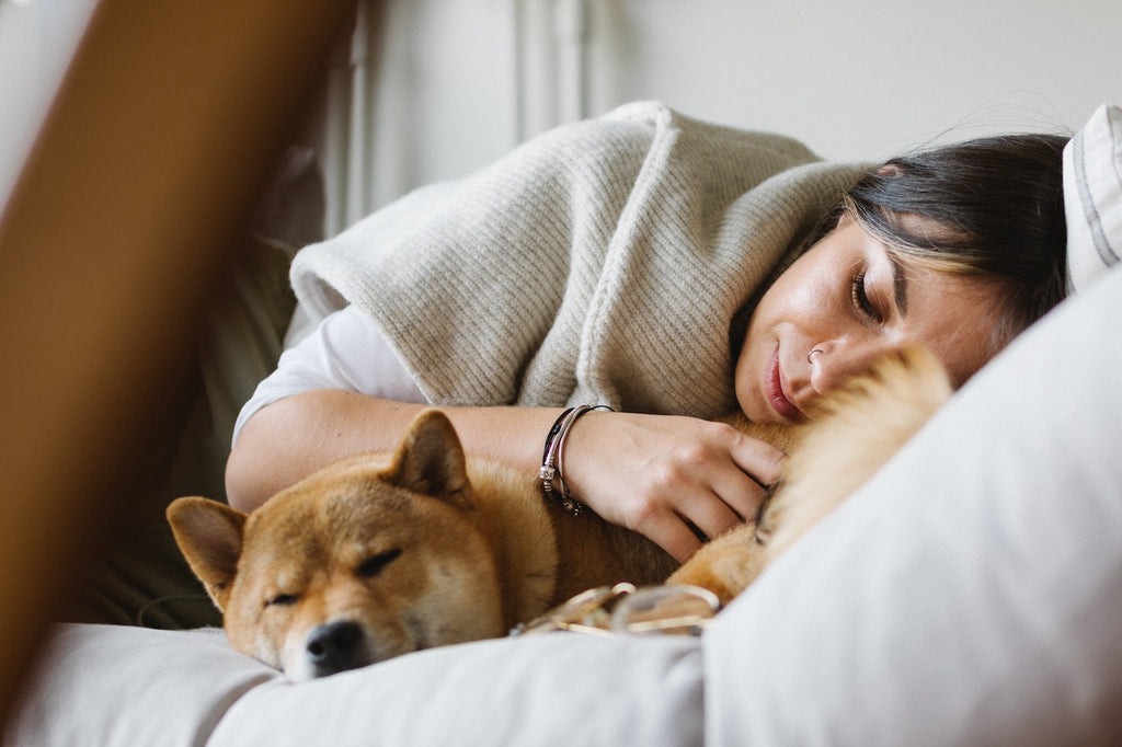 A young woman cuddling with her dog