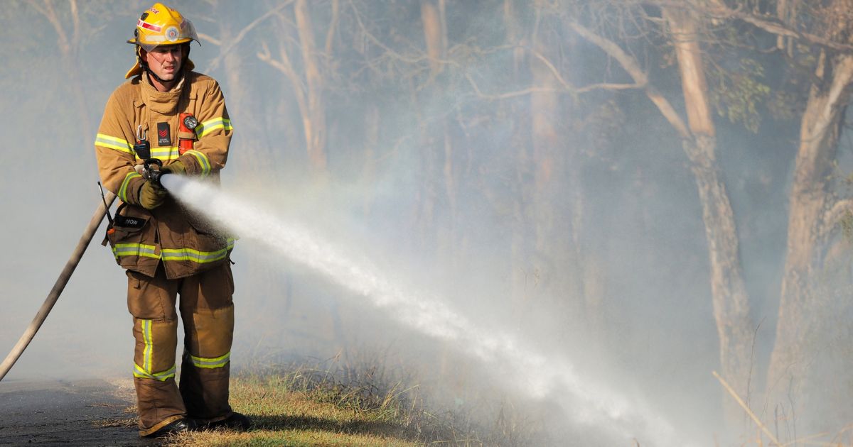 firefighter spraying water with hose