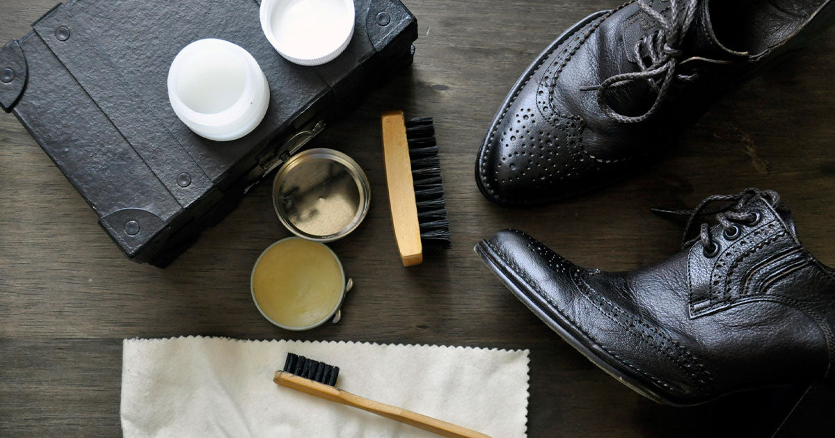 Table with black boots and shoe polish