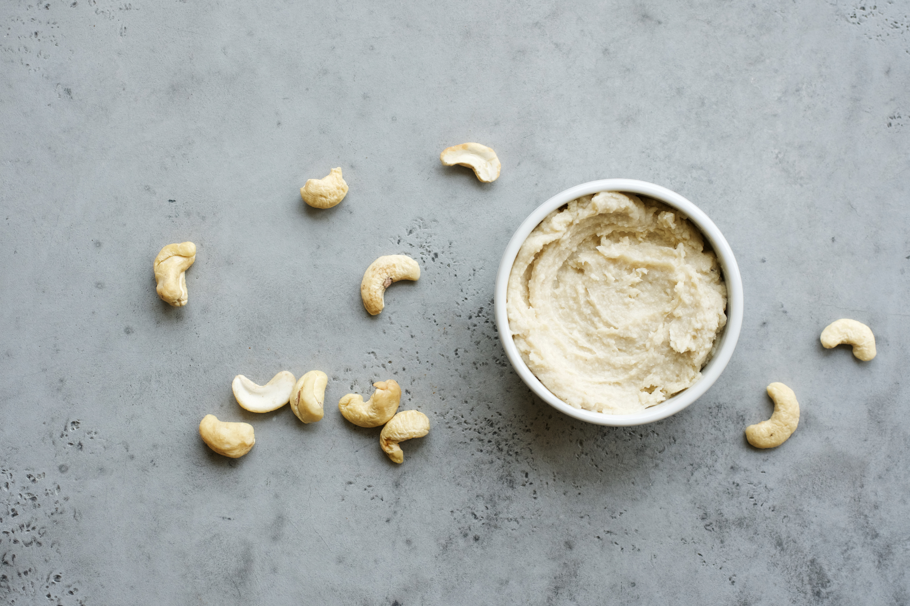 A jar of cashew butter spread on a white background, perfect for a delicious and creamy snack.