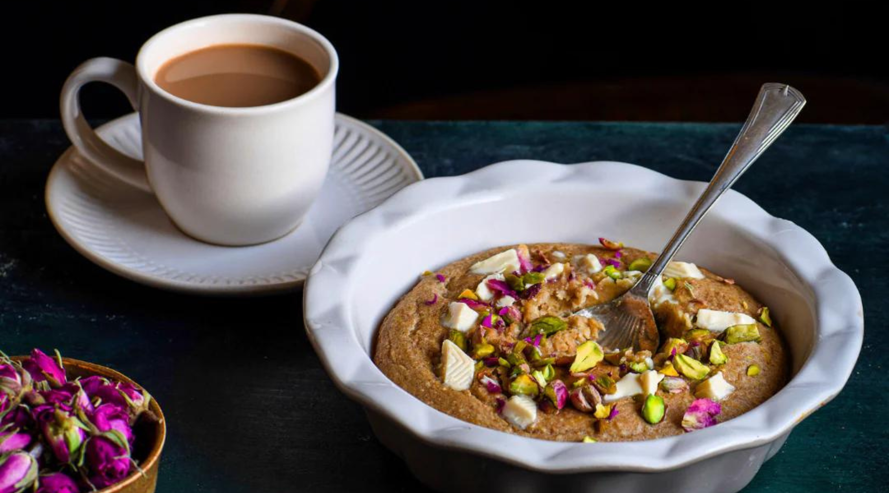 A bowl of baked oats with a spoon and a cup of coffee, perfect for a hearty breakfast.