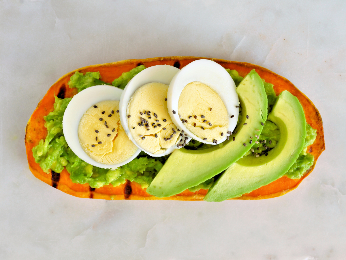 Sweet potato toast topped with avocado and hard boiled egg, a nutritious option for breakfast while following a Paleo Diet Meal Plan.