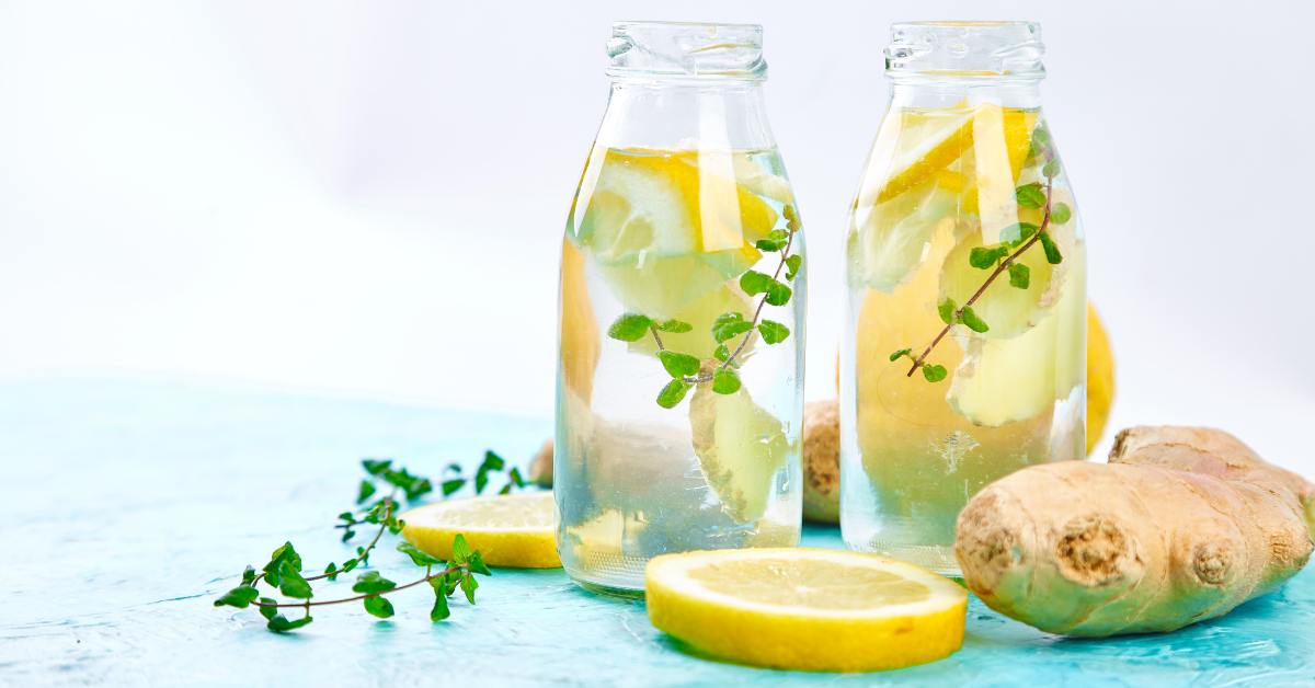 two glass bottles of ginger water with lemon slices 
