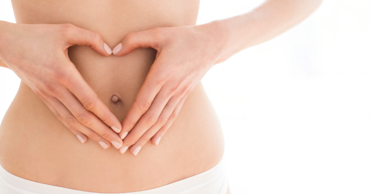 woman gesturing a heart shape on her stomach using her hands 