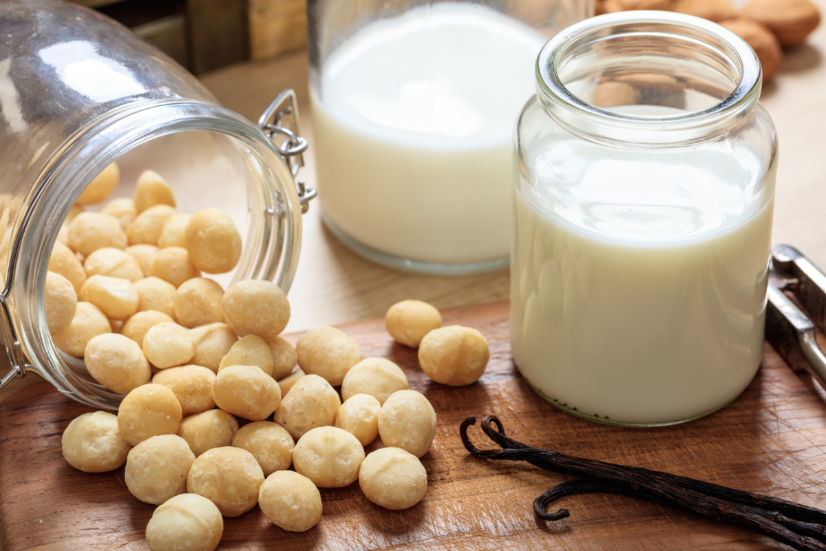 A wooden table displaying a glass of milk alongside a variety of nuts, creating a wholesome and inviting scene.