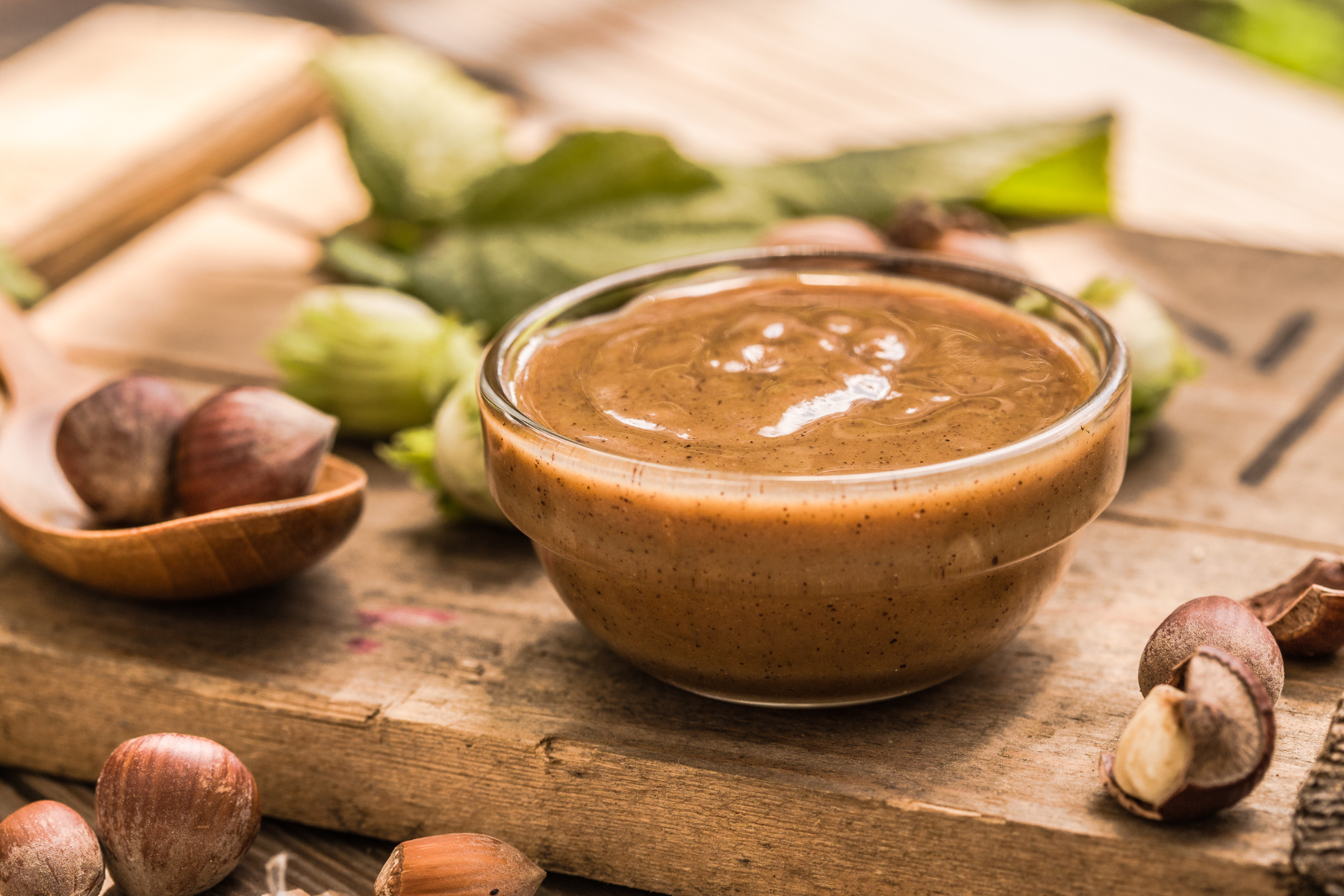 A bowl of hazelnut spread on a wooden cutting board, perfect for spreading on toast or using as a dip.