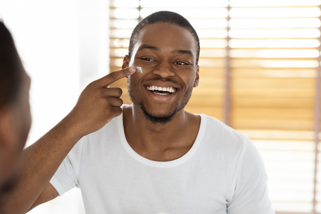 handsome black man applying best men's face moisturizer, urth