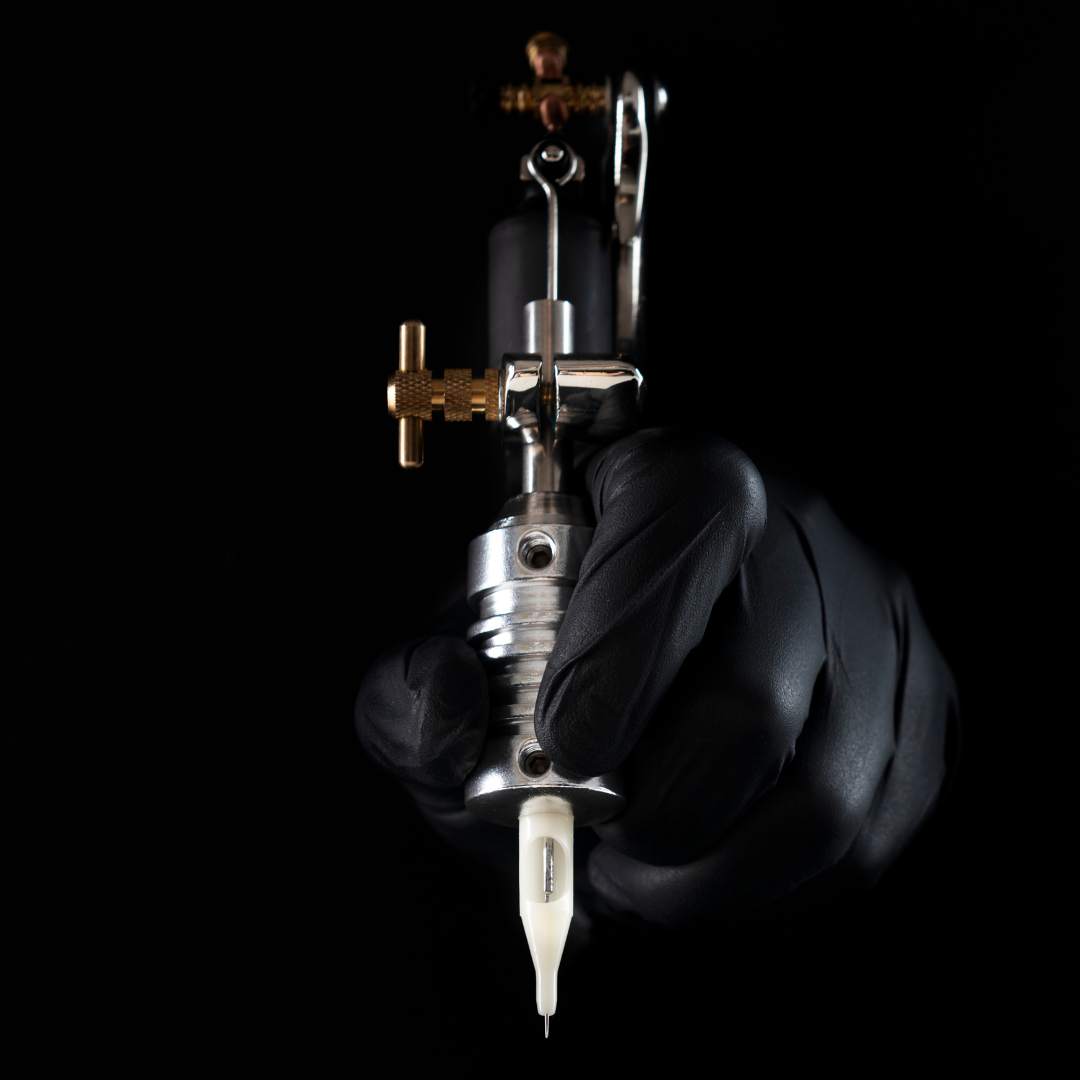 Shiver gallery art exhibition cover image - A hand wearing a black glove, holding a tattoo gun with a black background.