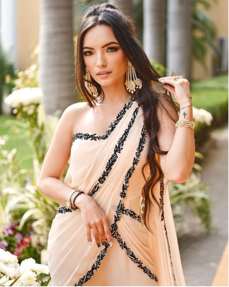 _akshita_s stuns in a Nude Drape Saree with a bralette blouse and tasseled  sleeves, featuring delicate embellishments that enhance her n