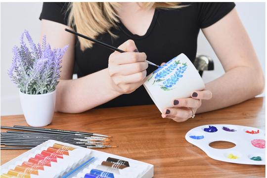 Woman painting with crafts on a mug