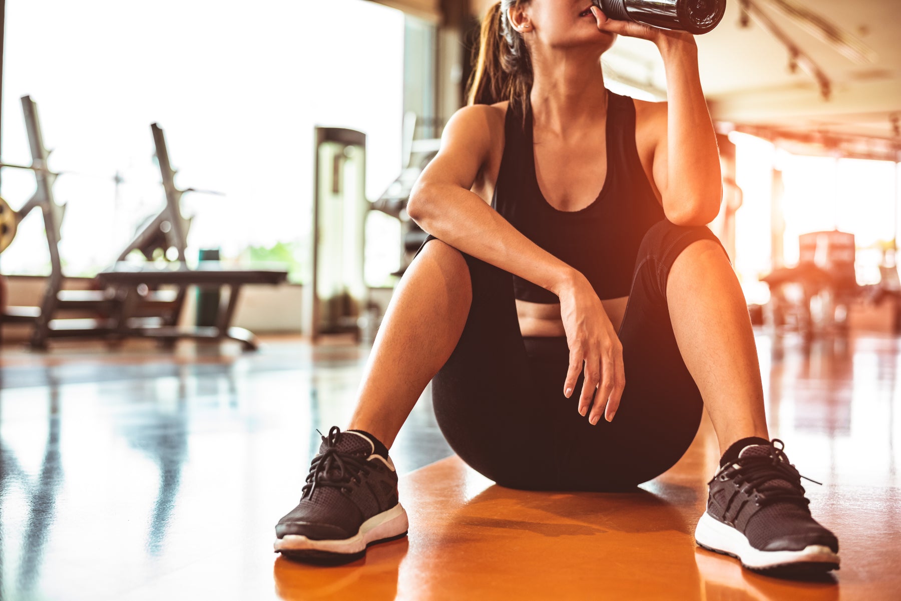 Woman resting and drinking from bottle after a workout