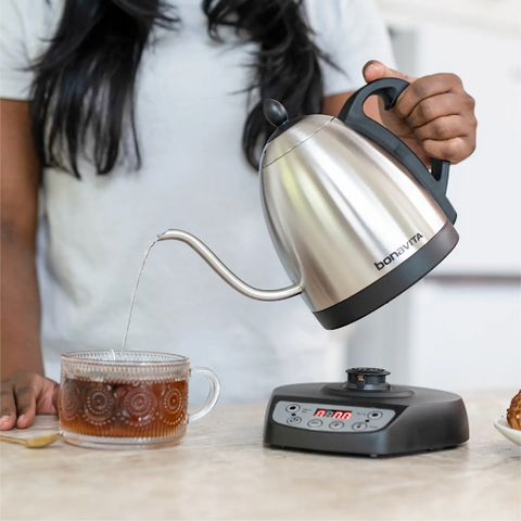 A woman pouring coffee from a kettle