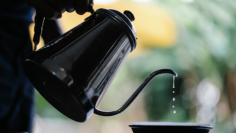 A Kettle pouring coffee into a cup
