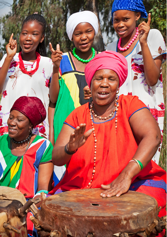 Group of women singing and beating a drum