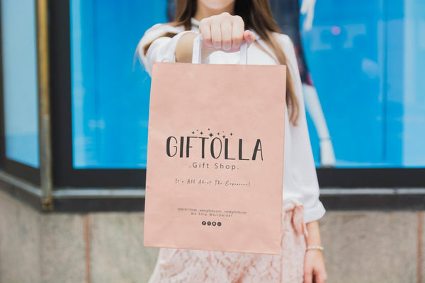 Women holding a bag that has Giftolla logo on it