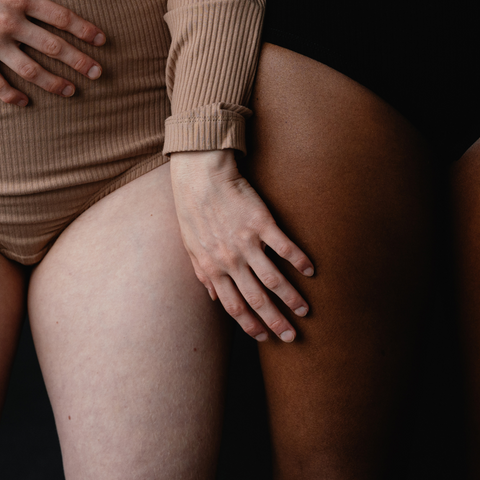 Slow Sex zwei Frauen berühren sich am Bein in Unterwäsche