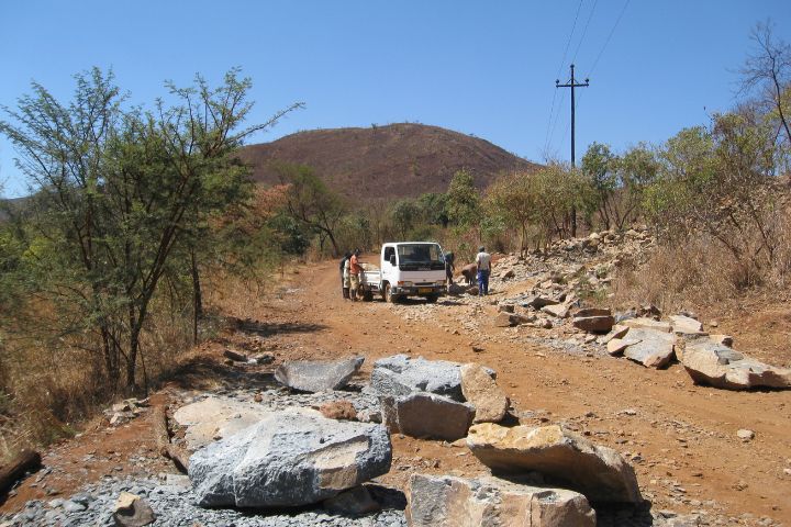 Truck on dirt road at the bottom of stone quarry mountain in Zimbabwe