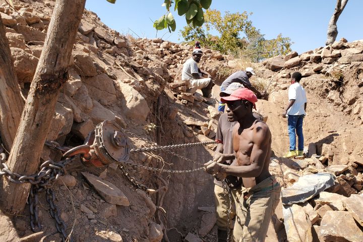 Zimbabwean miners using a pulley ingeniously designed from a tractor part to extract springstone rocks from a mine